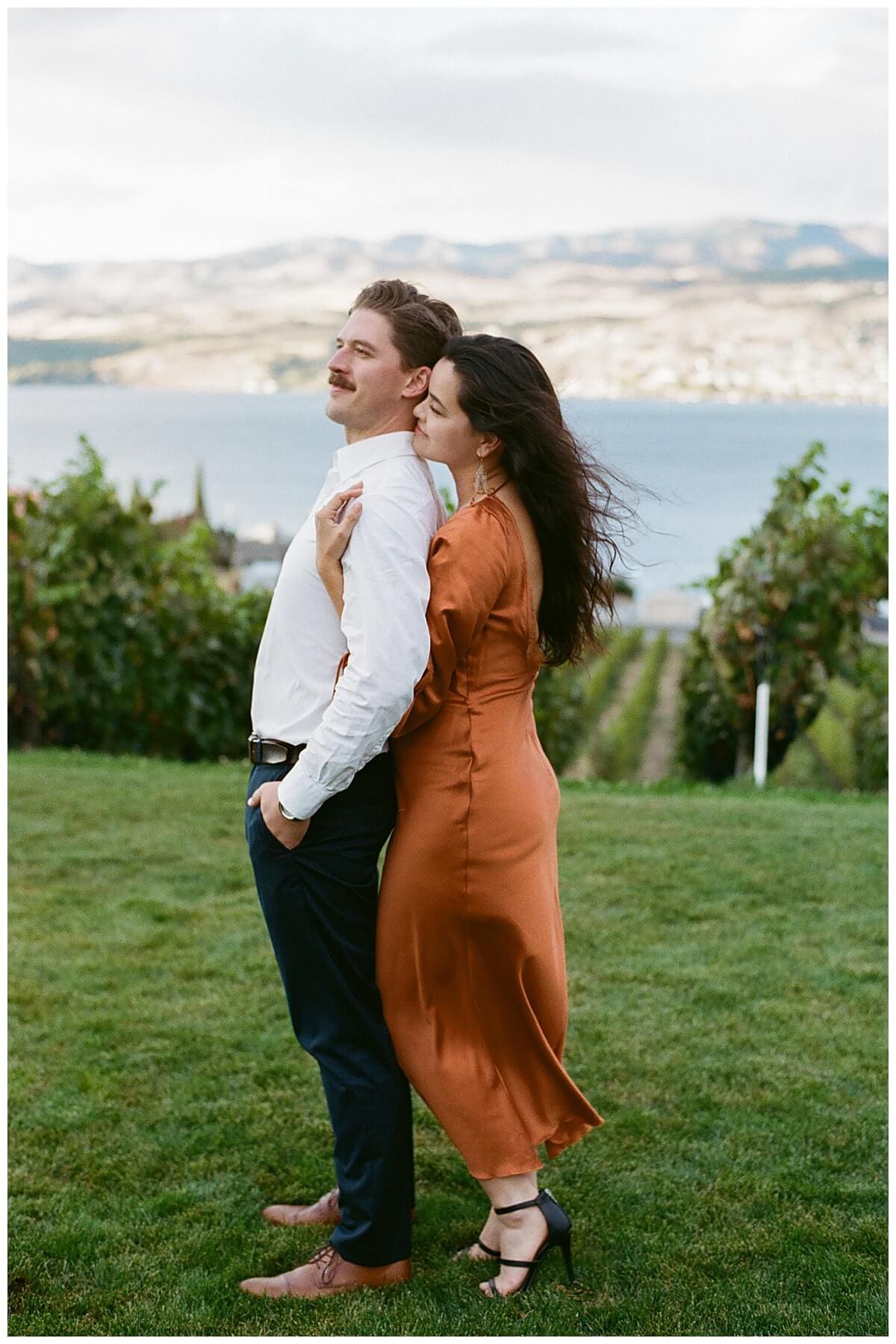 Couple walking through vineyard during Chelan winery engagement session in the fall